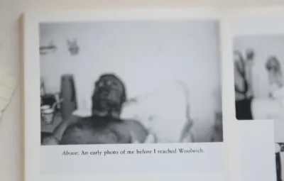 Black and white picture in a book with Simon Weston laying in a hospital bed before he got to Woolwich.