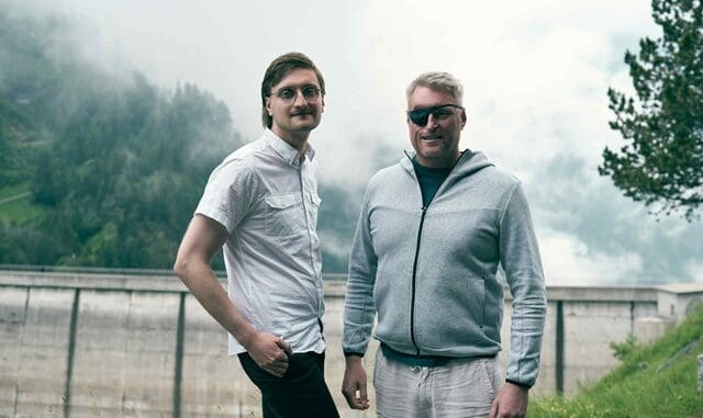 Dan Jackson and his son Dylan stand in a foggy mountain scene.