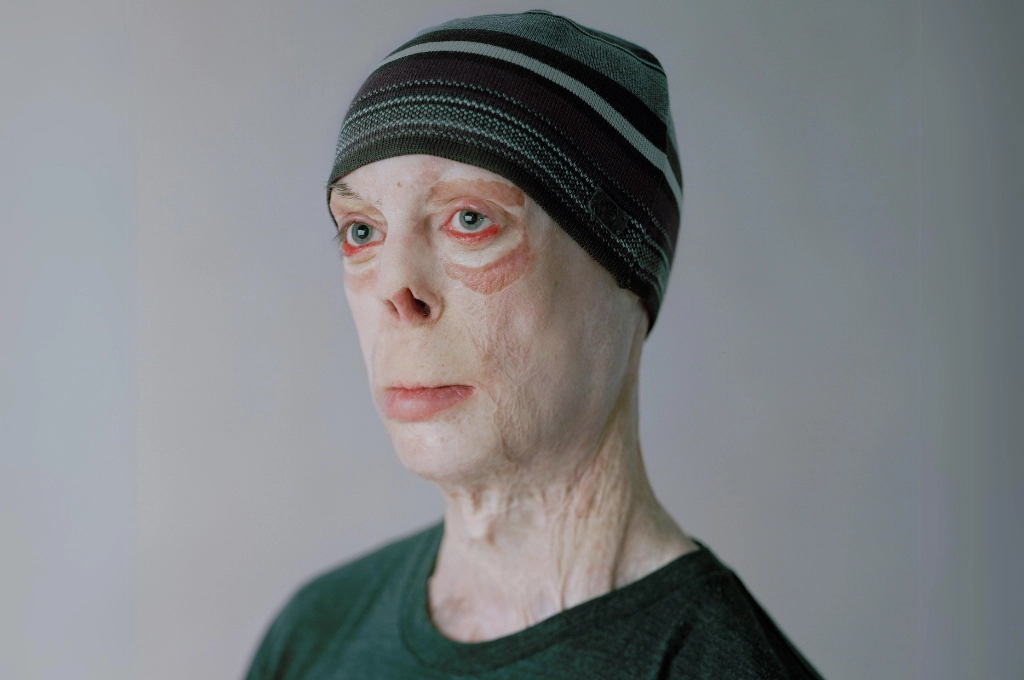 Portrait of a person wearing a dark headband against a neutral gray background.