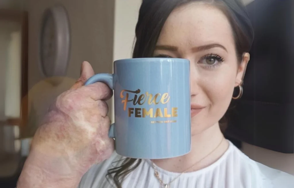 Woman holding light blue mug printed with "Fierce Female" text and gold lettering.