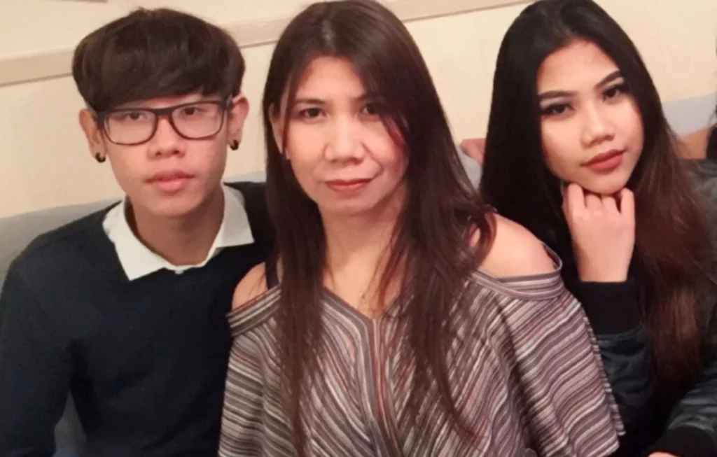 Three people posing together for a portrait photo indoors, smiling at the camera.