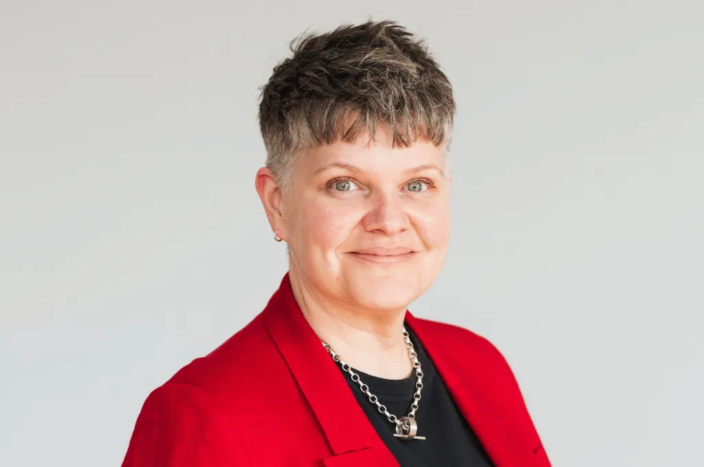 Charlotte Coates, team member at Scar Free Foundation, wearing red blazer against white background.