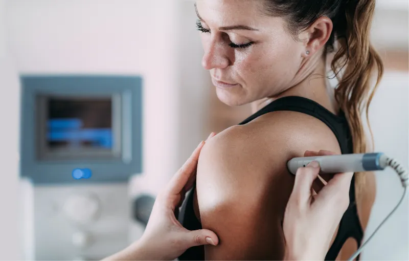 Ultrasound therapy being applied to a patient's shoulder during medical treatment session.