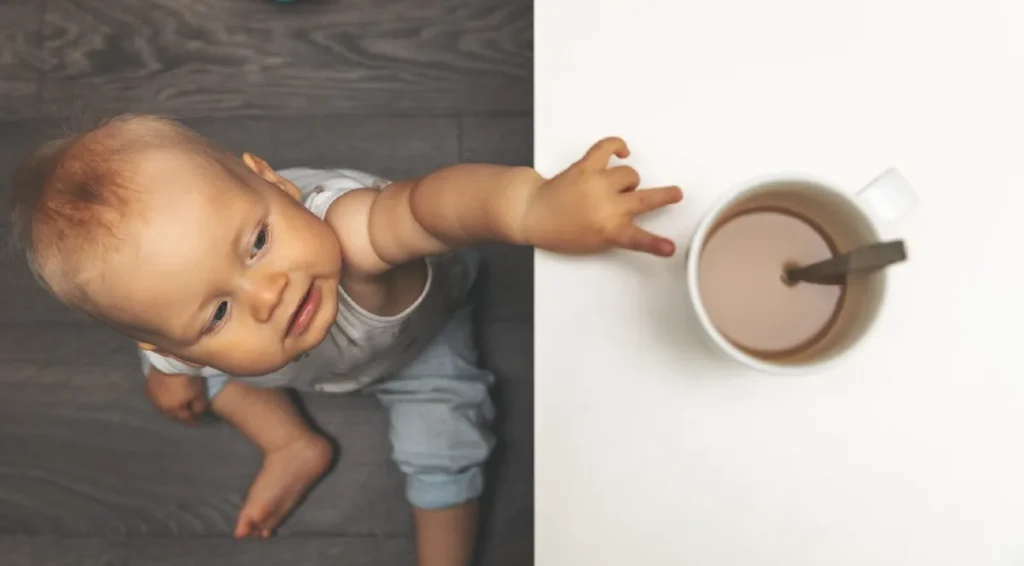 Toddler reaching up to a mug that has hot tea and a spoon in it